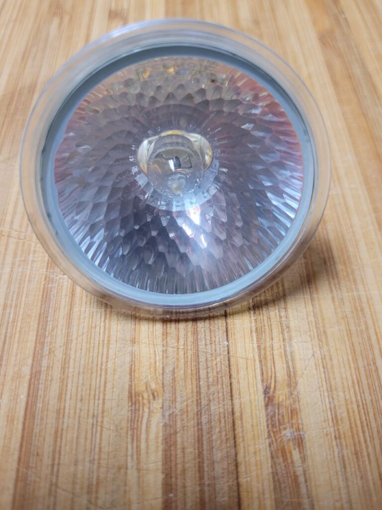 Bombilla LED blanca sobre una superficie de madera.