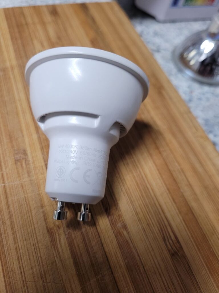 Bombilla LED blanca sobre una superficie de madera.